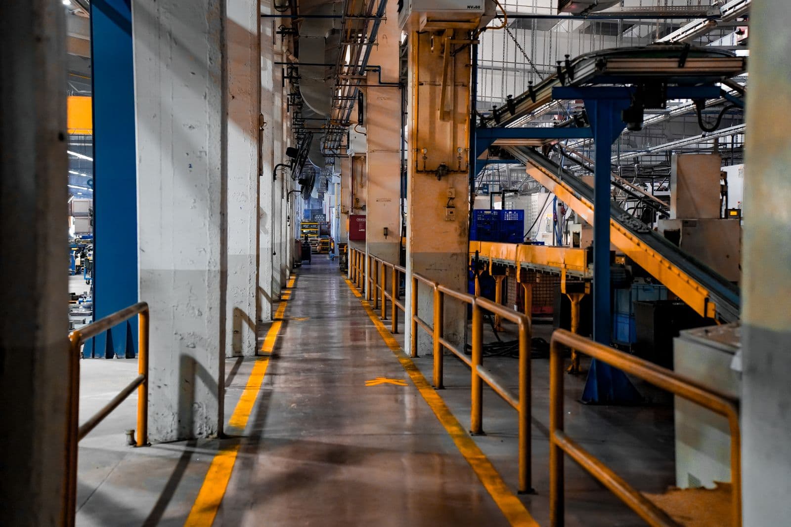Industrial facility interior with conveyor walkways and loading access